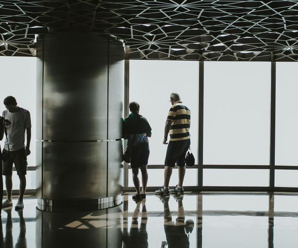 Person stretching gently near a large window at sunrise.